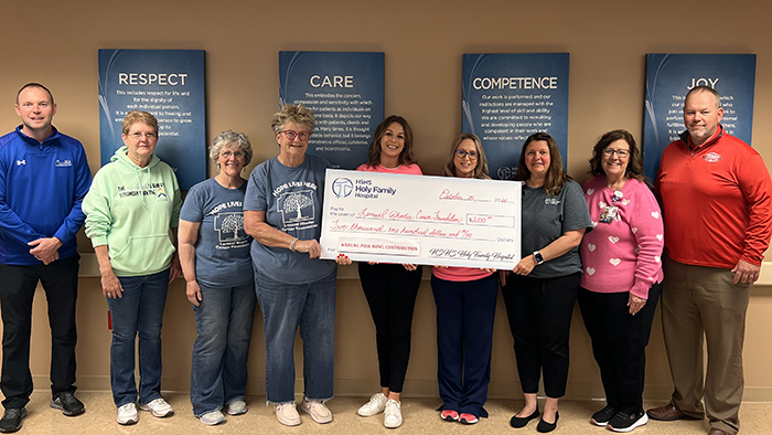 Teresa Cornelius, Chief Administrative Officer of HSHS Holy Family Hospital, and other hospital colleagues proudly present members of the Lemuel Rhodes Cancer Foundation with a donation of $2,100. Funds were raised at the annual “Pink Bowl,” which was played this year between the Vandalia Vandals and Greenville Comets. Funds help pay for medical care and other needs not covered by insurance for area cancer patients. Coaches Todd Hutchinson, Greenville Comets (on left end) and Jason Clay, Vandalia Vandals, (on right end) also joined the check presentation. 