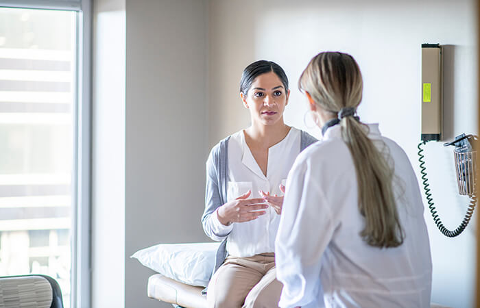 young woman speaking to blonde female nurse