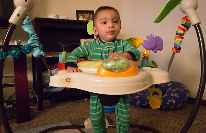 Baby Anthony playing in an interactive play center in a living room