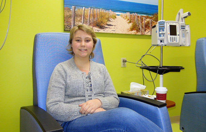 Natalie sitting in a chair for cancer treatment