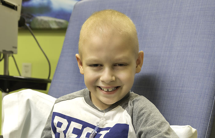 Riley sitting in a chair while getting treatment for cancer