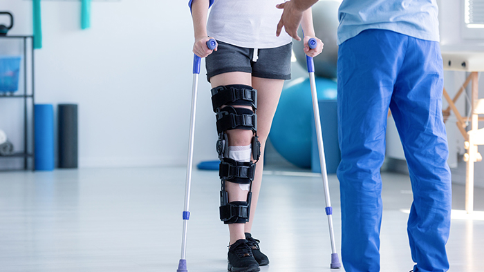 A person with leg wrapped in support device