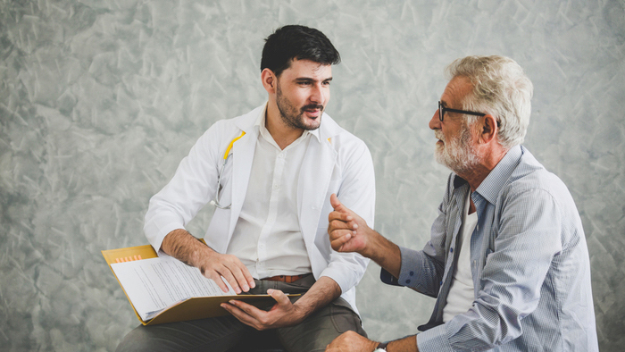 Older man talking with physician
