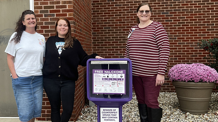 HSHS Good Shepherd Hospital Nurse Manager Karla Dixon (right) and representatives from the Moultrie-Shelby County ROSC Council pose next to a newly installed Narcan dispenser at the hos