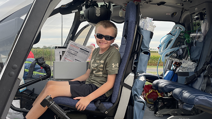 Young boy sitting in helicopter pilot seat