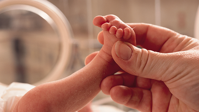 Tiny baby foot held in hand