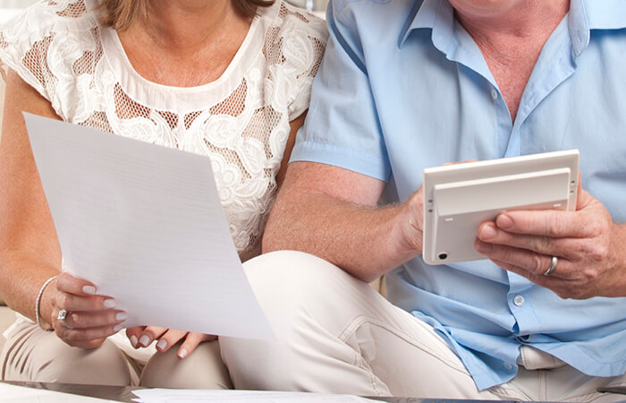 a white couple looking at bill statement and tablet 