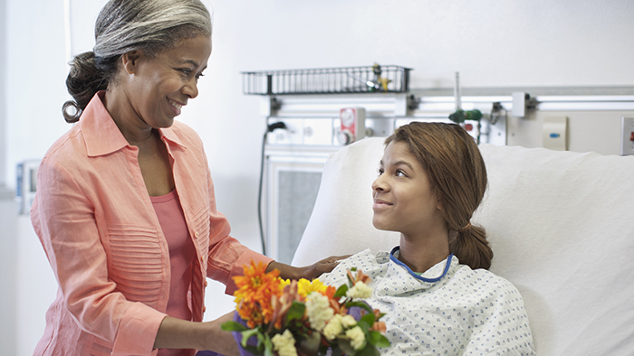 Volunteer bringing flowers to patient in hospital