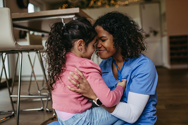 African-American nurse at home with daughter