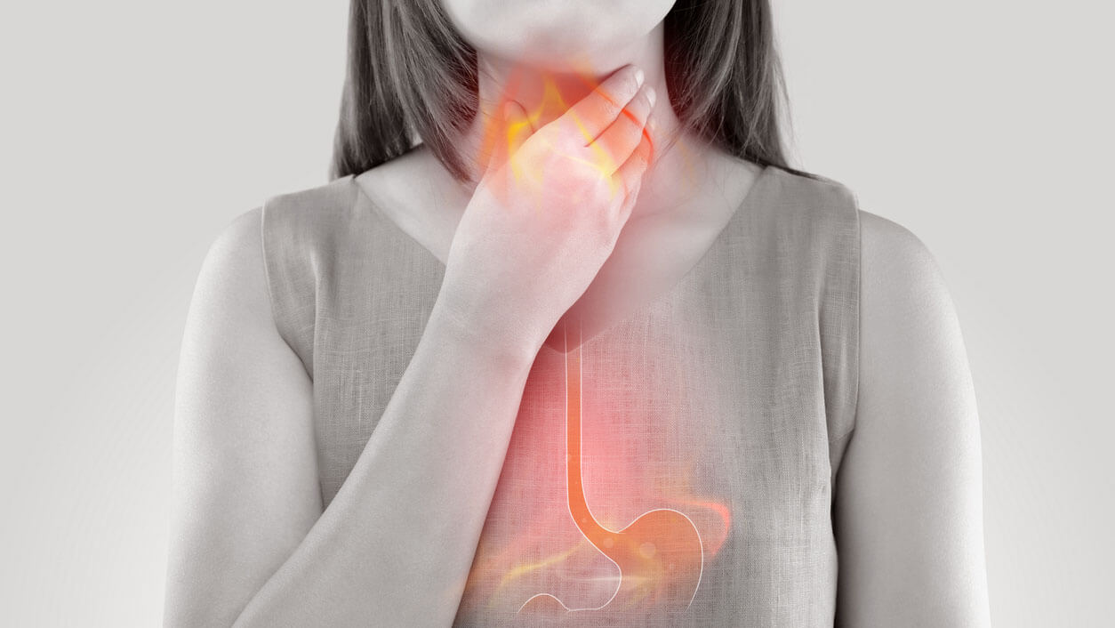 Woman clutching her throat in pain. A graphic of heartburn is illustrated in red, while image is black and white.