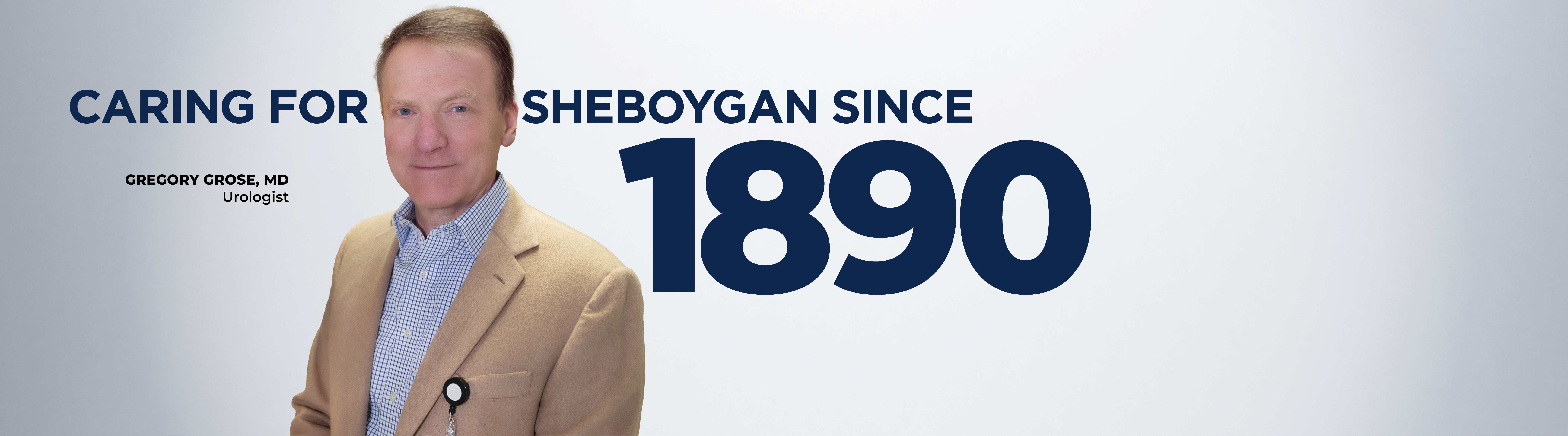 photo of Gregory Grose standing facing camera with text on screen that reads "Caring for Sheboygan since 1890"