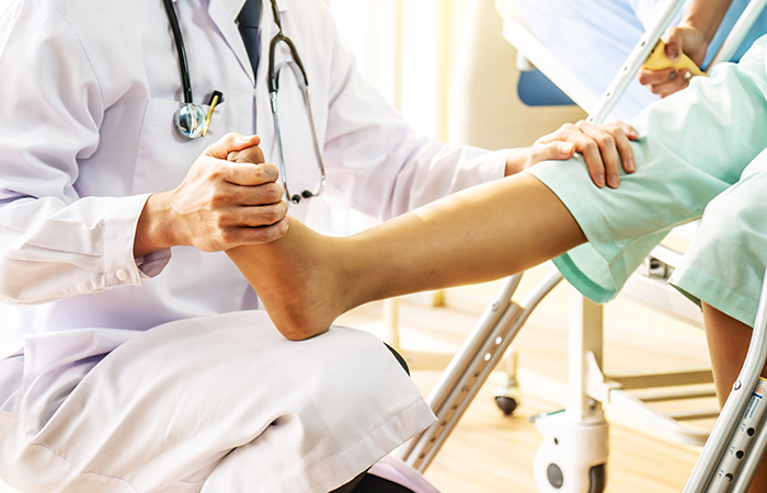 Doctor having patient press against foot after wearing crutch